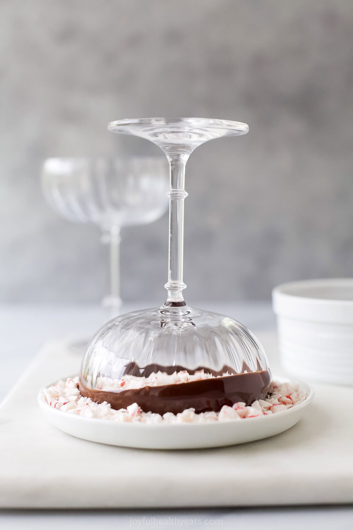 Dipping the chocolate rimmed glass into crushed peppermint candies. 