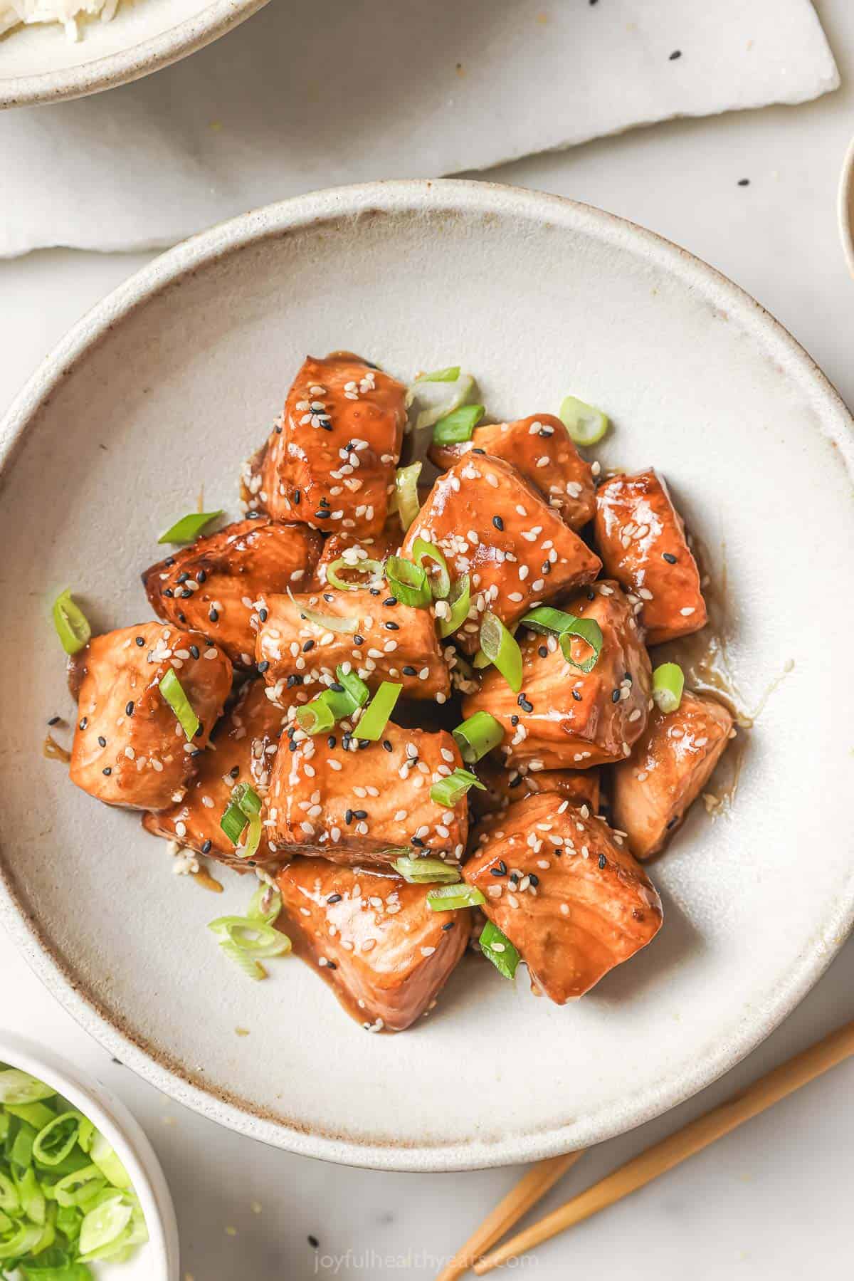 These crispy salmon bites are so easy to make in the air fryer and the sweet-and-tangy Asian-inspired marinade makes them irresistible! Overhead view of crispy salmon bites in bowl