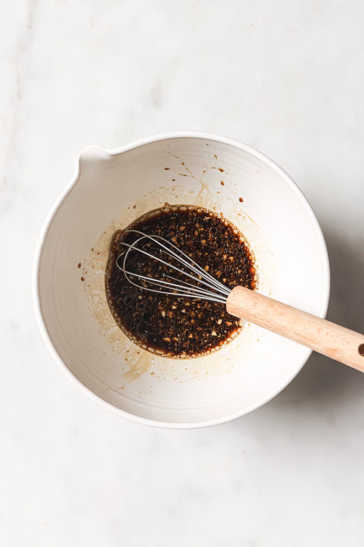 Marinade for crispy salmon bites in bowl with whisk