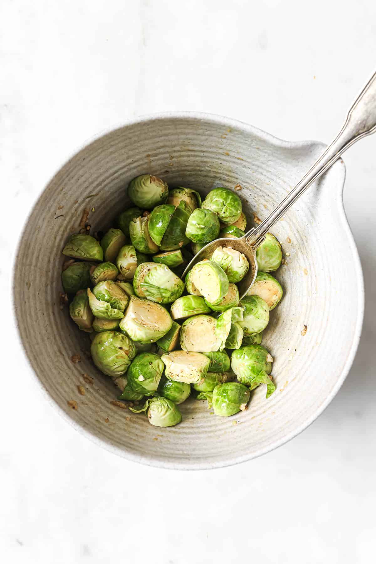 Overhead view of Brussels sprouts in bowl with seasonings