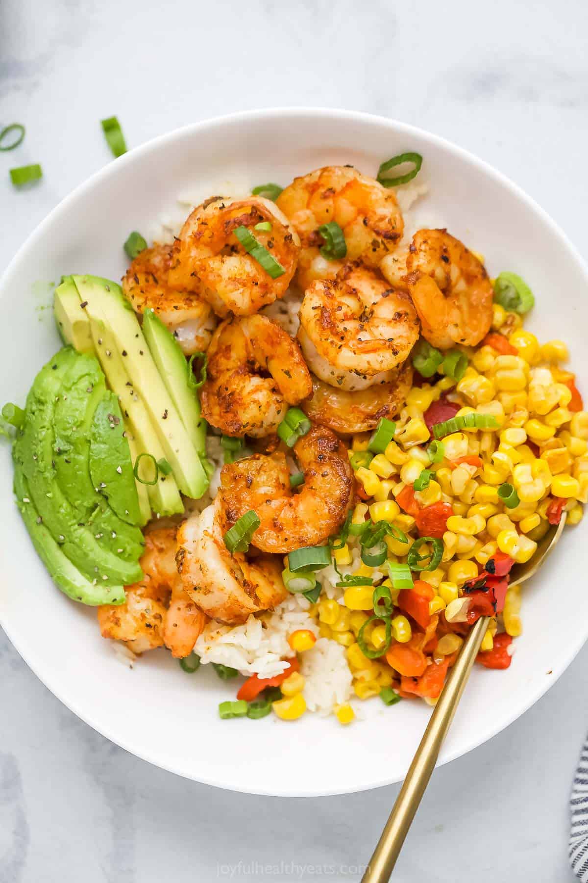 Blackened shrimp bowls are packed with bold spices, garlicky corn relish, and plenty of fresh ingredients for a healthy meal with big flavor! Overhead view of blackened shrimp bowl with corn relish