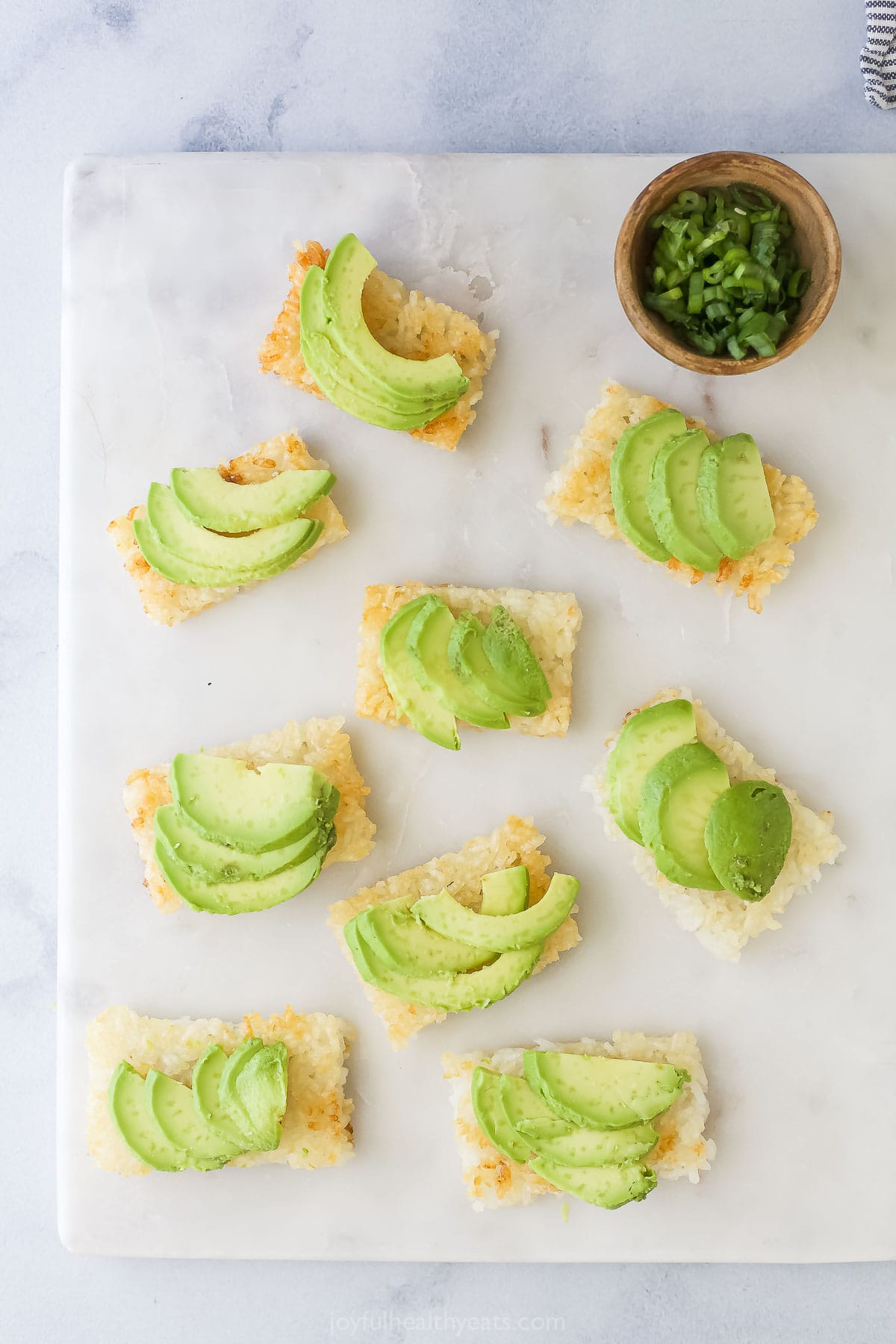 Overhead view of avocado added to crispy rice