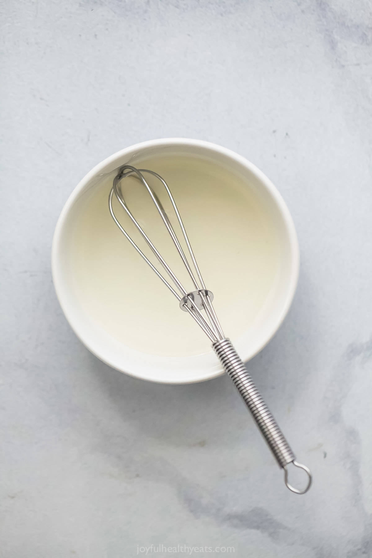 Rice and sugar in small bowl with whisk